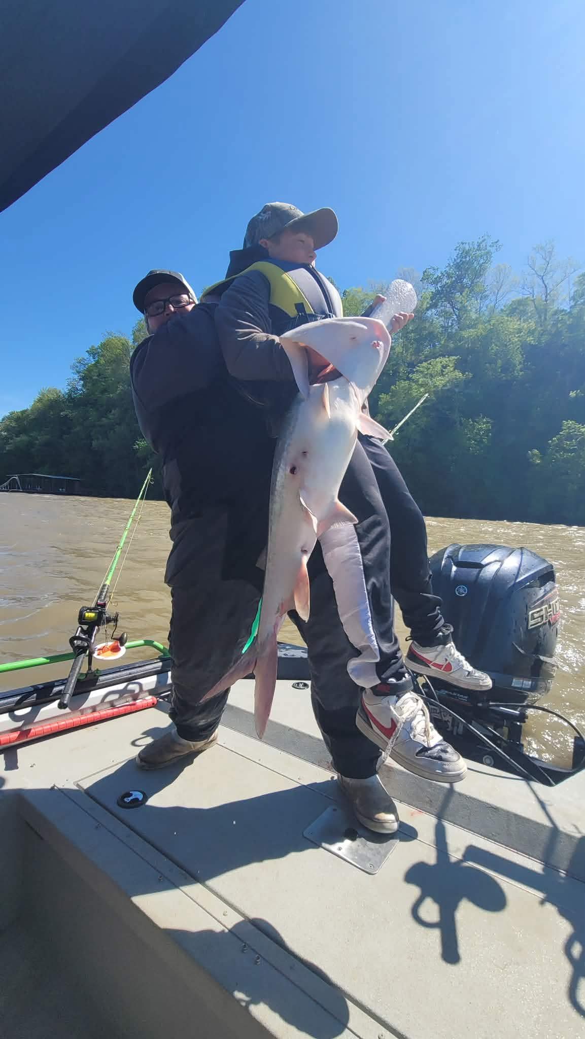 Father and son with a giant blue catfish